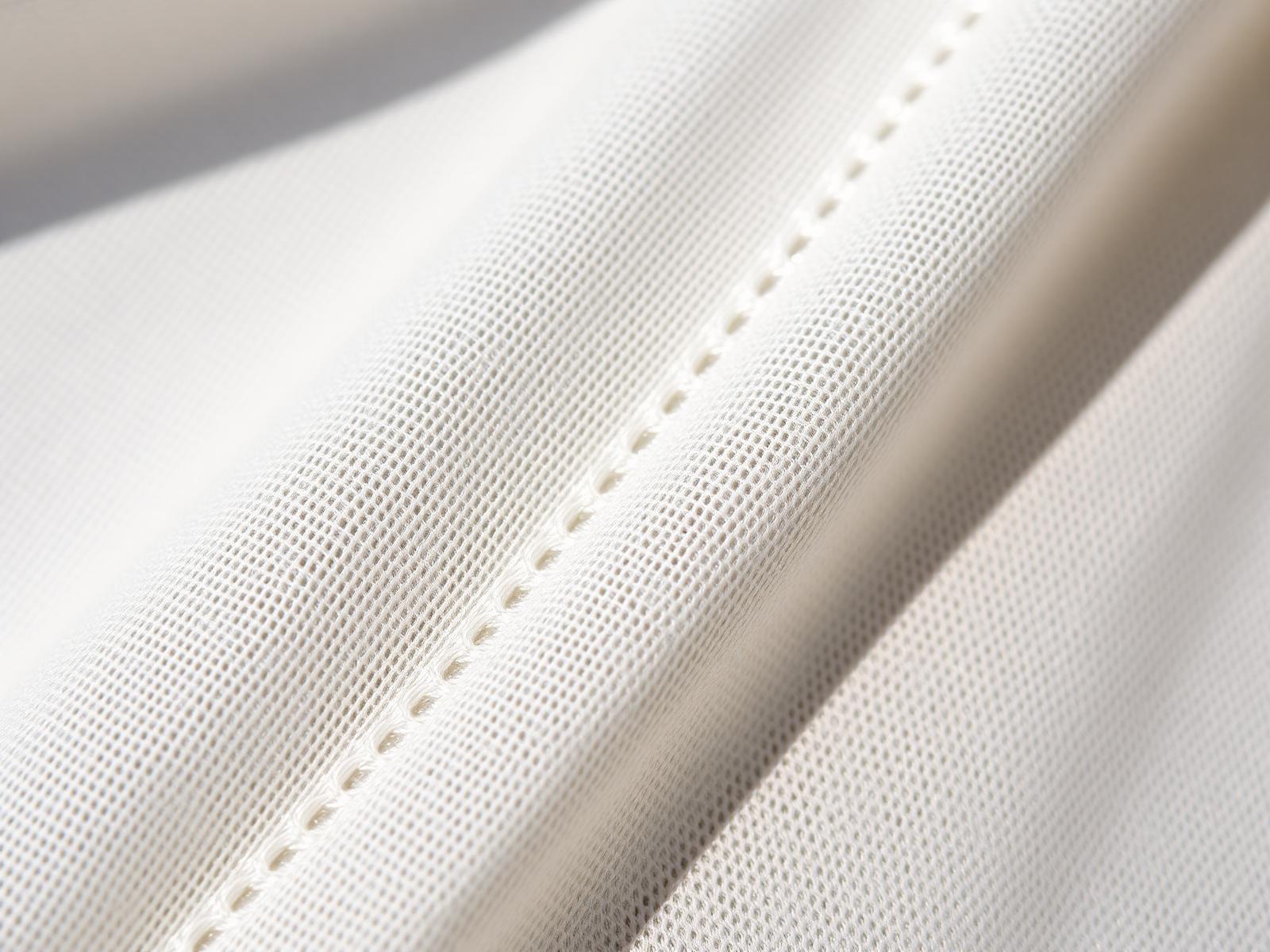 Macro detail of fine white Chikankari shadow stitching